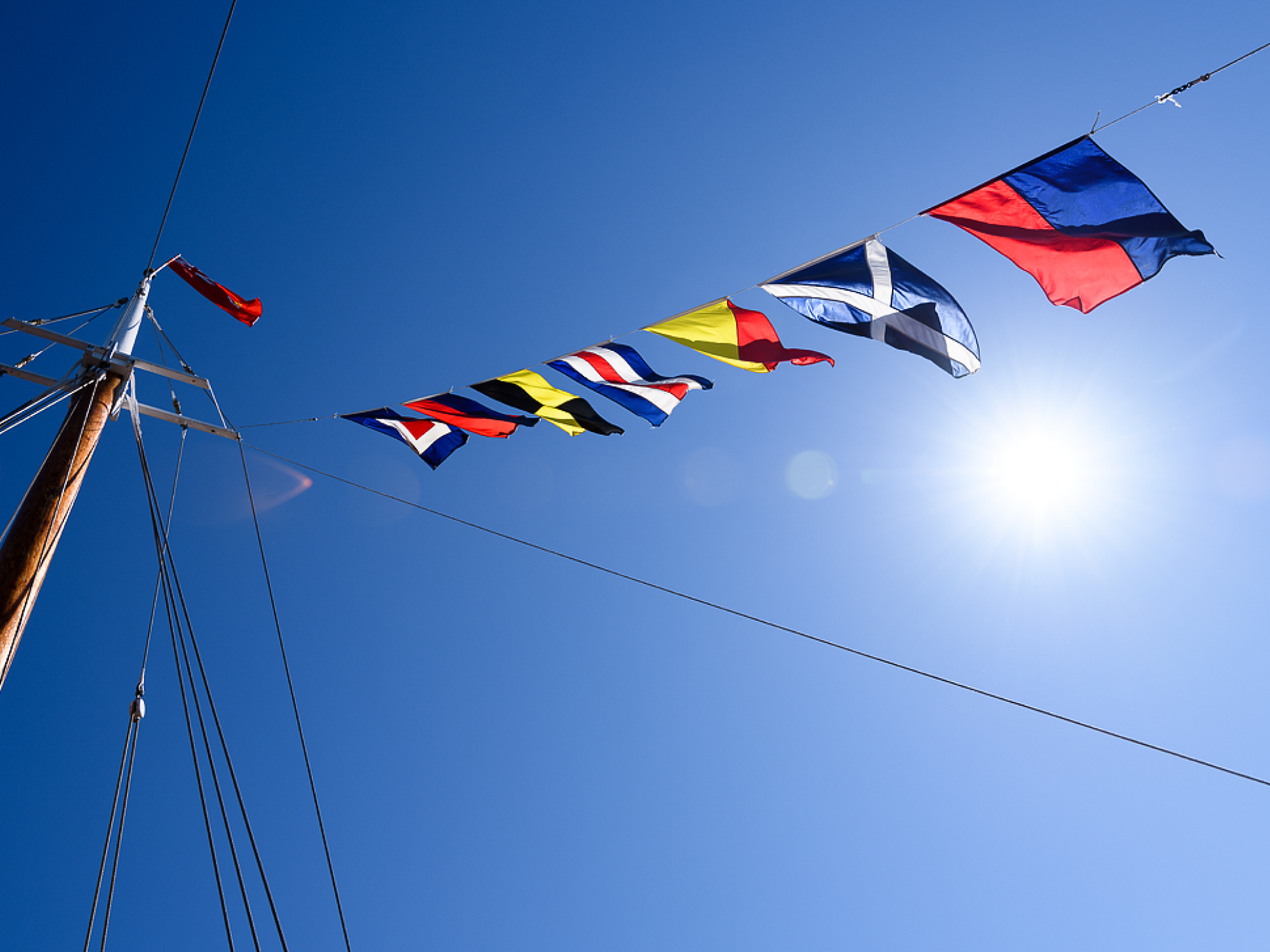Ships flags on a blue sky day.